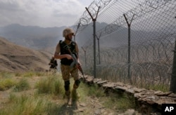 Pakistan Army troops patrol along the fence on the Pakistan-Afghanistan border at Big Ben hilltop post in Khyber district, Pakistan. (Anjum Naveed/AP)