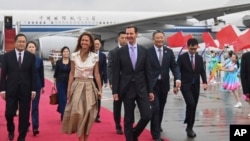 In this photo released by Xinhua News Agency, Syrian President Bashar Assad, center right, and first lady Asma Assad arrive in Hangzhou, China, on Sept. 21, 2023. (Huang Zongzhi/Xinhua via AP, File)