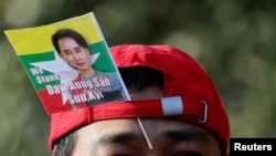A Myanmar protester residing in Japan uses a flag with an image of deposed Myanmar leader Aung San Suu Kyi during a rally to mark the second anniversary of Myanmar's 2021 military coup, outside the Embassy of Myanmar in Tokyo on February 1, 2023. (Issei Kato/Reuters)