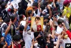 Myanmar nationals living in Thailand hold a picture of former Myanmar leader Aung San Suu Kyi during a protest marking the two-year anniversary of Myanmar's military takeover, in Bangkok on February 1, 2023. (Sakchai Lalit/AP)