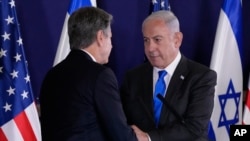 U.S. Secretary of State Antony Blinken, left, and Israel's Prime Minister Benjamin Netanyahu shake hands after their statements to the media inside The Kirya, which houses the Israeli Ministry of Defense, after their meeting in Tel Aviv on October 12, 2023. (Jacquelyn Martin/AP)