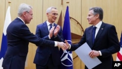 Finnish Foreign Minister Pekka Haavisto, left, shakes hands with United States Secretary of State Antony Blinken, right, during a meeting of NATO foreign ministers at NATO headquarters in Brussels, Tuesday, April 4, 2023. (Johanna Geron, Pool Photo via AP)