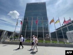 People walk past the United Nations headquarters building on the East Side of Manhattan,in New York City, on June 8, 2021. (AFP/Daniel SLIM)