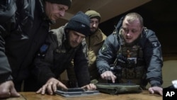 A Ukrainian commander of a unit aka Kurt (right) speaks to his comrades at the frontline in Ukraine, Feb. 13, 2023. (AP/Evgeniy Maloletka)