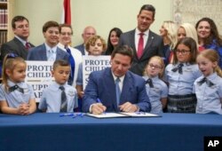 Florida Governor Ron DeSantis signs the Parental Rights in Education bill at Classical Preparatory School on March 28, 2022, in Shady Hills, Florida. (Douglas R. Clifford/Tampa Bay Times/via AP)