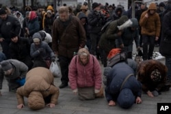 People pray in the Kyiv Pechersk Lavra monastery complex in Kyiv, on March 29, 2023. (Andrew Kravchenko/AP)