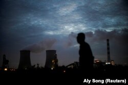 A man walks past a coal-fired power plant in Shanghai, China, October 14, 2021. (REUTERS/Aly Song)