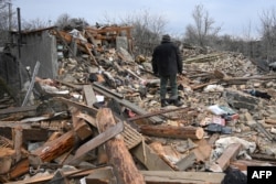 People search the rubble of a house following a Russian strike in the village of Velyka Vilshanytsia, some 50km from Lviv, on March 9, 2023. (Yuri Dyachyshyn/AFP)