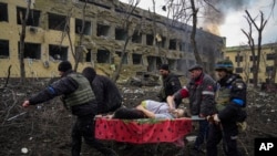 Ukrainian emergency personnel and police officers evacuate injured pregnant woman Iryna Kalinina, 32, from a maternity hospital that was damaged by a Russian airstrike in Mariupol on March 9, 2022. (Evgeniy Maloletka/AP) 
