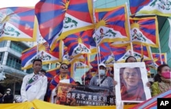 Tibetans living in Taiwan and their supporters hold up Tibetan national flags and the portrait of the Dalai Lama during a march in Taipei on March 5, 2023, marking the 64th anniversary of the failed 1959 Tibetan uprising against Chinese rule. (Chiang Ying-ying/AP)