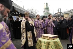 Priests of the Ukrainian Orthodox Church pray with their supporters after resisting a government order to leave the Kyiv Pechersk Lavra monastery complex in Kyiv, on April 1, 2023. (Roman Hrytsyna/AP)