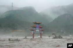 A traditional gate is seen inundated by flood waters in the Miaofengshan area on the outskirts of Beijing, China, Aug. 1, 2023. (AP/Ng Han Guan)
