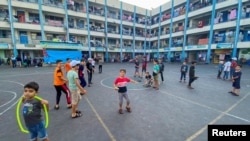 Palestinian children, who fled their houses due to Israeli strikes, play as they shelter in a United Nations-run school, in Gaza City, October 12, 2023. (REUTERS/Arafat Barbakh)