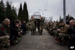 Ukrainian servicemen of the Khartia battalion carry the coffin of Vladyslava "Aida" Chernyh during a funeral ceremony in Kharkiv on December 30, 2022. (Evgeniy Maloletka/AP)