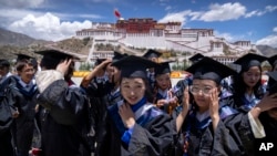 Graduates of the College of Science of Tibet University prepare to take a group photo on a square near the Potala Palace in Lhasa in western China's Tibet Autonomous Region, as seen during a government organized visit for foreign journalists, Tuesday, June 1, 2021. (AP/Mark Schiefelbein)