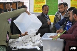 Election officials prepare to count ballot papers at a polling booth in Dhaka on January 7, 2024. (Munir Uz Zaman/AFP)