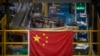 A Chinese flag hangs near an automated parcel handling line at a warehouse for an online retailer in Beijing, Nov. 11, 2020. (AP/Mark Schiefelbein)