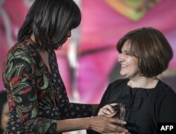 Former U.S. first lady Michelle Obama, left, presents Elena Milashina of Russia with the Secretary of State's International Women of Courage Award inside the Dean Acheson Auditorium of the U.S. Department of State on March 8, 2013, in Washington D.C. (Paul J. Richards/AFP)
