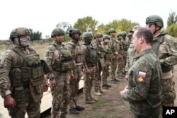 Russian Security Council Deputy Chairman Dmitry Medvedev, front right, speaks to Russian military members during his visit to a military training range in a Russian-occupied part of Ukraine's Donetsk region on September 15, 2023. (Sputnik/via AP)