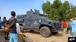 An armored police vehicle is seen in the Zabarmari district, near Maiduguri, on November 6, 2023, during a burial of farmers that were victims of an attack.