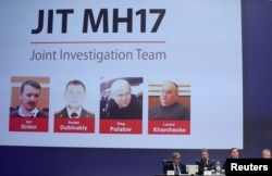 Four individuals tried for downing MH17, three of whom were convicted, are shown on screen while international investigators presented their findings in Nieuwegein, Netherlands, on June 19, 2019. (Eva Plevier/Reuters)