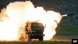 A launch truck fires the High Mobility Artillery Rocket System (HIMARS) during training at the Yakima Training Center, Washington State, USA, on May 23, 2011 (Tony Overman, AP)