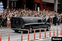 A vehicle carrying the body of the late former Japanese Prime Minister Shinzo Abe leaves Zojoji Temple in Tokyo, Japan, after his funeral on July 12, 2022. Abe was shot while campaigning for a parliamentary election. (Issei Kato/Reuters)