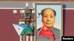 Djibouti and Chinese national flags near the Tiananmen Square portrait of China's late leader Mao Zedong, November 23, 2017. (Jason Lee/Reuters) 