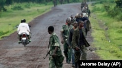 A column of Congolese M23 rebels is seen running on the Goma to Rushuru road as they look for FDLR (Force Democratique de Liberation du Rwanda) returning from an incursion into Rwanda Near Kibumba, north of Goma Tuesday Nov. 27, 2012. (Jerome Delay/AP)