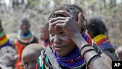 A woman waits for food distribution by the United States Agency for International Development (USAID), in Kachoda, Turkana area, northern Kenya, July 23, 2022.