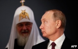 Russian President Vladimir Putin and Patriarch Kirill visit the exhibition "Memory of Generations: the Great Patriotic War in Pictorial Arts," on National Unity Day in Moscow on November 4, 2019. (SHAMIL ZHUMATOV/AFP)