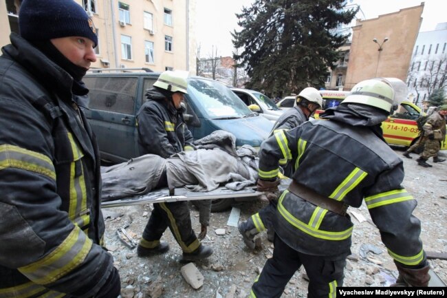 Rescuers carry the body of a victim on a stretcher outside the regional administration building, which city officials said was hit by a missile attack, in central Kharkiv on March 1, 2022. (Vyachesla Madiyevskyy/Reuters)