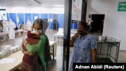 A woman reacts as she visits her relatives inside a care centre for the coronavirus disease (COVID-19) patients at an indoor sports complex in New Delhi, India, July 20, 2020.