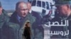 A woman passes a billboard showing Russian President Vladimir Putin in Damascus, Monday, March 7, 2022. The Arabic poster reads "The victory for Russia." (Omar Sanadiki/AP)