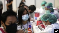 A health worker administers a dose of the Sinovac COVID-19 vaccine to a woman in Bangkok on May 31, 2021.