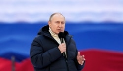 Russian President Vladimir Putin delivers a speech during the concert marking the eighth anniversary of Russia's annexation of Crimea.