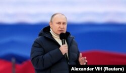 Russian President Vladimir Putin delivers a speech during the concert marking the eighth anniversary of Russia's annexation of Crimea.