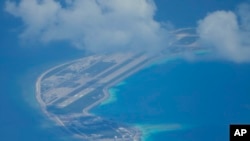 An airstrip made by China is seen beside structures and buildings at the man-made island on Mischief Reef in the South China Sea on March 20, 2022. (Aaron Favila/AP)