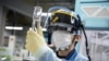 An employee conducts a tritium measurement on a sample of contaminated water at the Tokyo Electric Power Company Fukushima Dai-ichi nuclear power plant in Okuma, Japan, March 5, 2022. (AFP/Charly Triballeau)