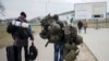 A man carries combat gear as he leaves Poland to fight in Ukraine, at the border crossing in Medyka, Poland, Wednesday, March 2, 2022. (AP Photo/Markus Schreiber, File)