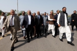 Pakistani lawmakers of the united opposition walk towards the parliament house building to cast their vote on a motion of no-confidence to oust Prime Minister Imran Khan, in Islamabad, on April 3, 2022. (Akhtar Soomro/Reuters)