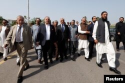 Pakistani lawmakers of the united opposition walk towards the parliament house building to cast their vote on a motion of no-confidence to oust Prime Minister Imran Khan, in Islamabad, on April 3, 2022. (Akhtar Soomro/Reuters)