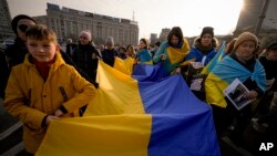 People carry a large Ukrainian flag during a protest against Russia's war on Ukraine, marking the first anniversary of Russia's full-scale, in Bucharest, Romania, on February 24, 2023. (Andreea Alexandru/AP) 