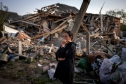 Anna Shevchenko, 35, reacts in the presence of her bombed out home in Irpin, near Kyiv, on Tuesday, May 3, 2022. (Emilio Morenatti/AP).
