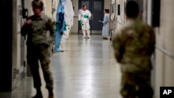Biological science specialists wear biosafety protective clothing for handling viral diseases at the U.S. Army Medical Research and Development Command at Fort Detrick in Frederick, Maryland, on March 9, 2020. (Andrew Harnik/AP)