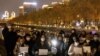 People in Beijing gather for a vigil and hold white sheets of paper on November 27, 2022, in protest over COVID-19 restrictions. (Thomas Peter/Reuters) 