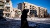 An elderly local resident walks past a destroyed residential building in Chasiv Yar on January 7, 2023, amid the Russian invasion of Ukraine. (Dimitar Dilkoff/AFP)