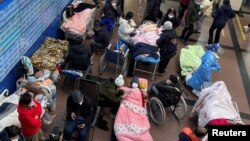 Patients lie on beds and stretchers in a hallway in the emergency department of a hospital, amid the coronavirus disease (COVID-19) outbreak in Shanghai, China, Jan. 4, 2023.