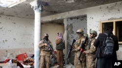 Taliban fighters inspect a house after an eight-hour gun battle between Taliban and Islamic State group fighters at a suspected ISIS hideout on the outskirts of Jalalabad, east of Kabul, on November 30, 2021. (Shir Shah Hamdard/Associated Press)
