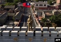 A military statue and Taiwanese flag on top of an arch built in remembrance of the Battle of Guningtou in 1949 at Taiwan's Kinmen islands, which lie 3.2 kilometers from mainland China's coast. Photo taken on October 20, 2020. (Sam Yeh/AFP)